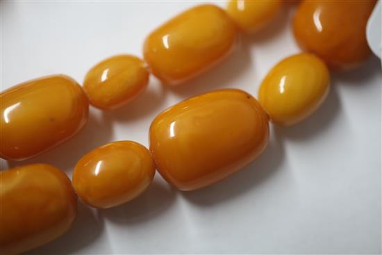 A single strand oval amber bead necklace, 104cm.